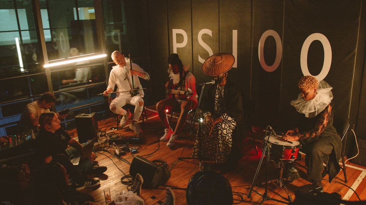 Músicos tocando para una audiencia pequeña en una sala con luz cálida